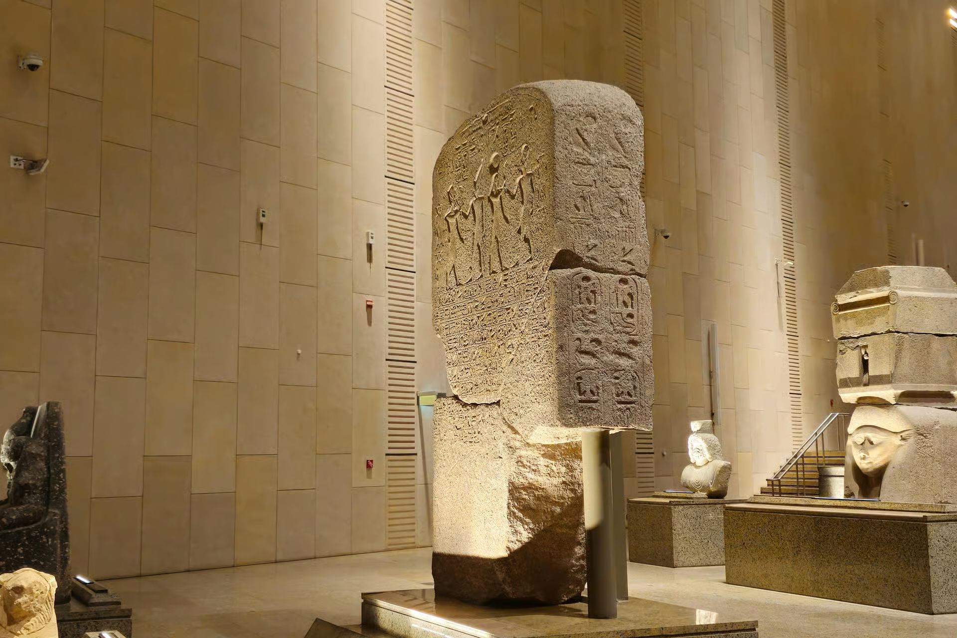 Woman in Egyptian queen costume posing against hieroglyphic background