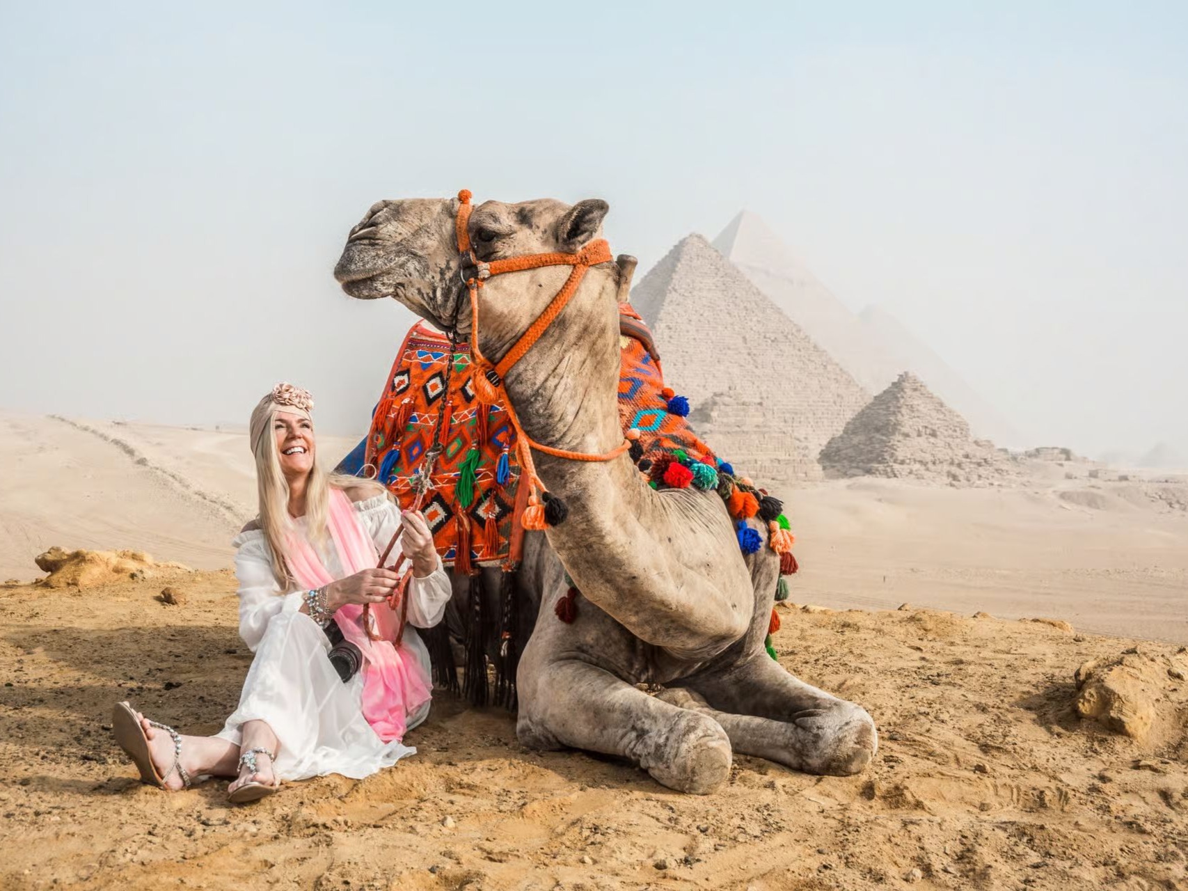 Woman in Egyptian queen costume posing against hieroglyphic background