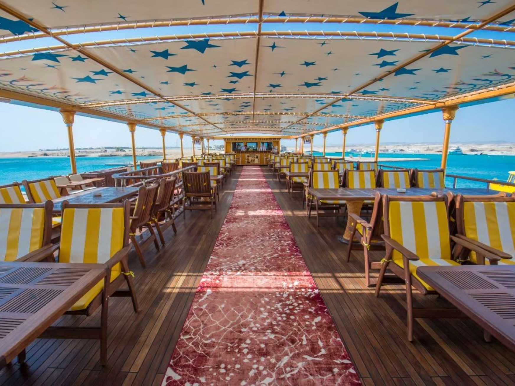 Spacious upper deck with yellow striped chairs and star-patterned canopy