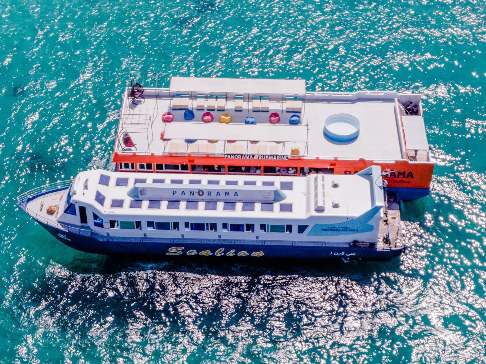 Luftaufnahme des Panorama-Glasbodenboots und seiner schwimmenden Station im türkisfarbenen Wasser