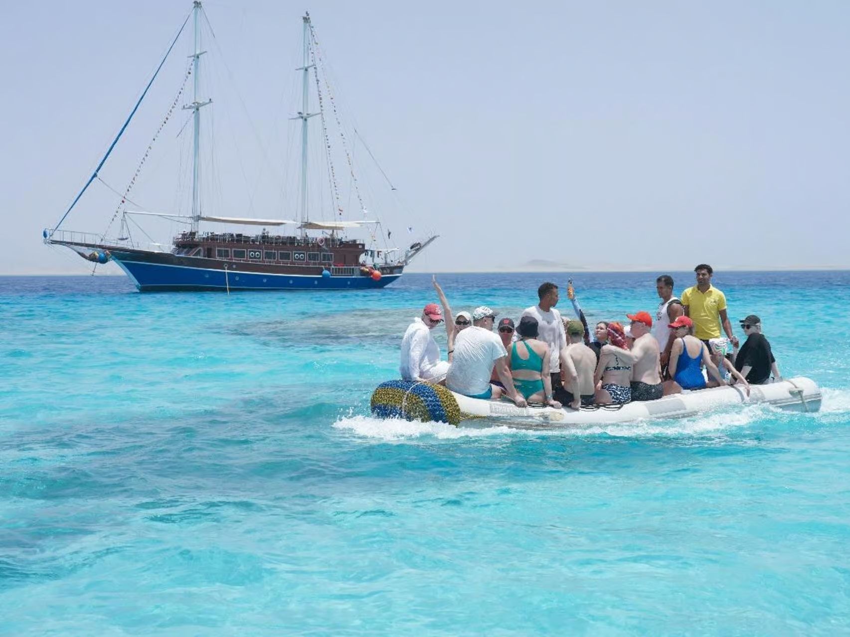 Group of tourists on inflatable boat heading to a pirate ship