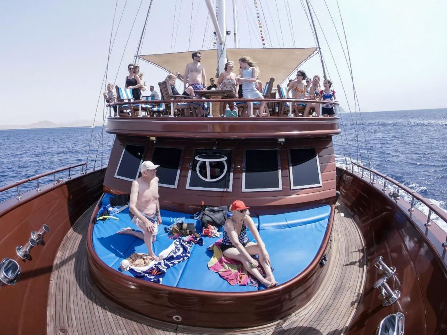 Guests relaxing on the upper deck of a wooden pirate-style boat