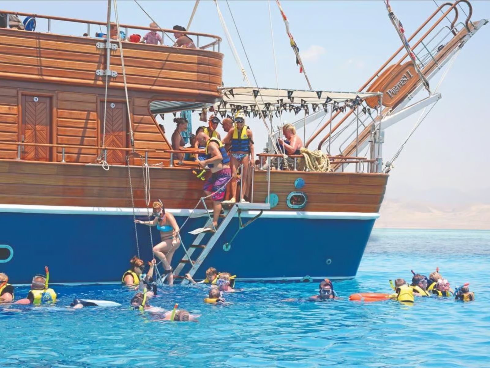 Guests entering the water from the boat for snorkeling
