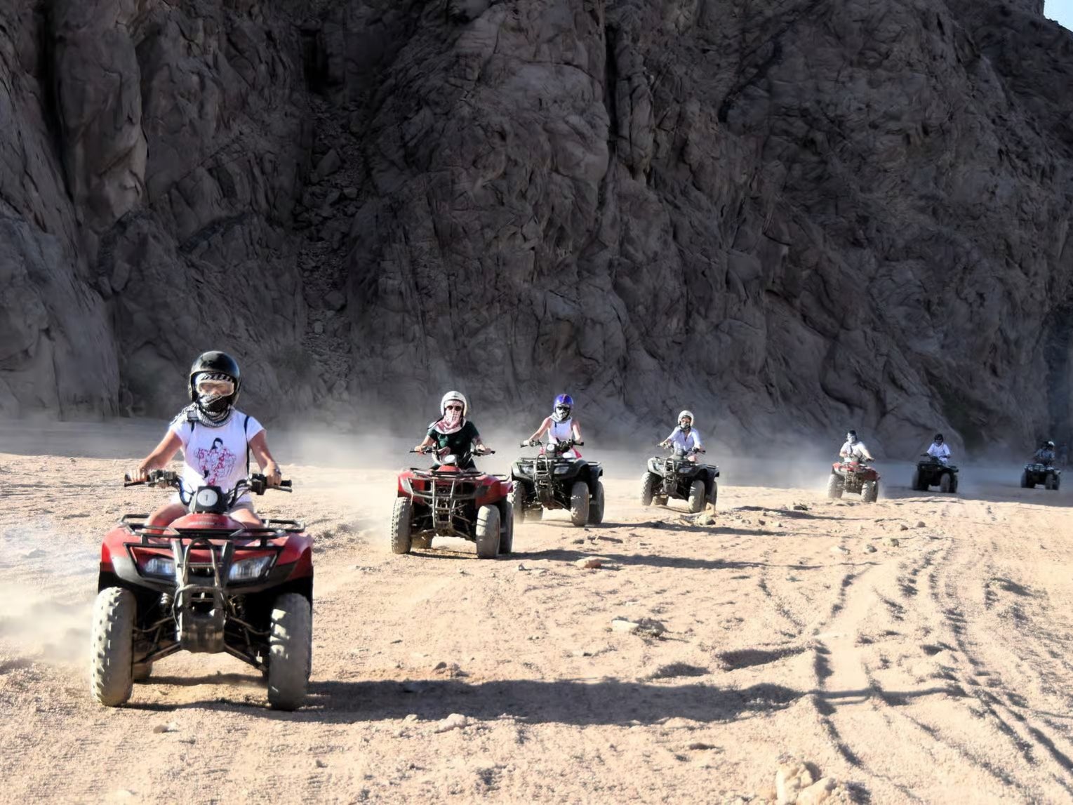 Quad bikes riding across desert dunes