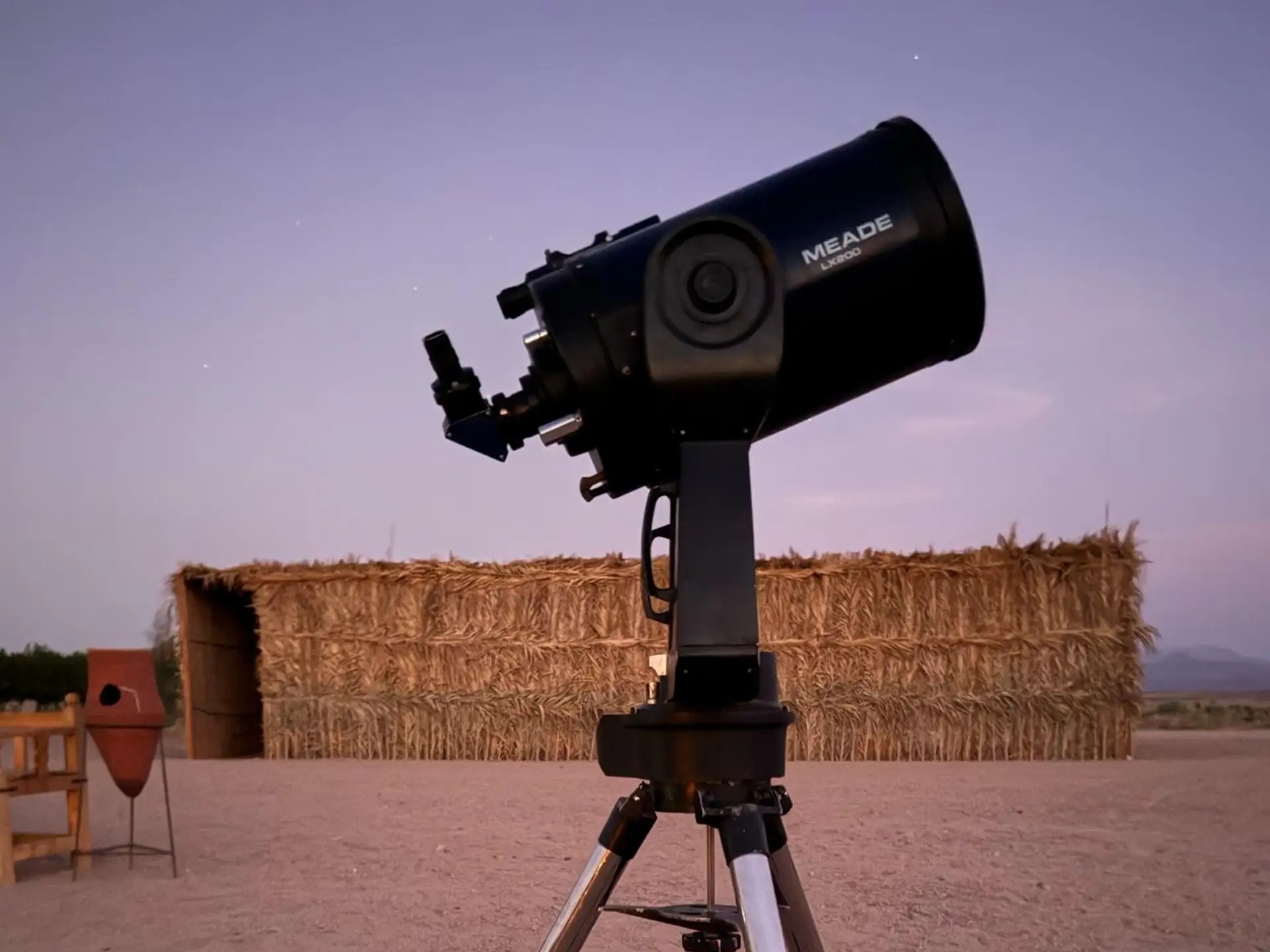 Telescope setup in the desert at sunset