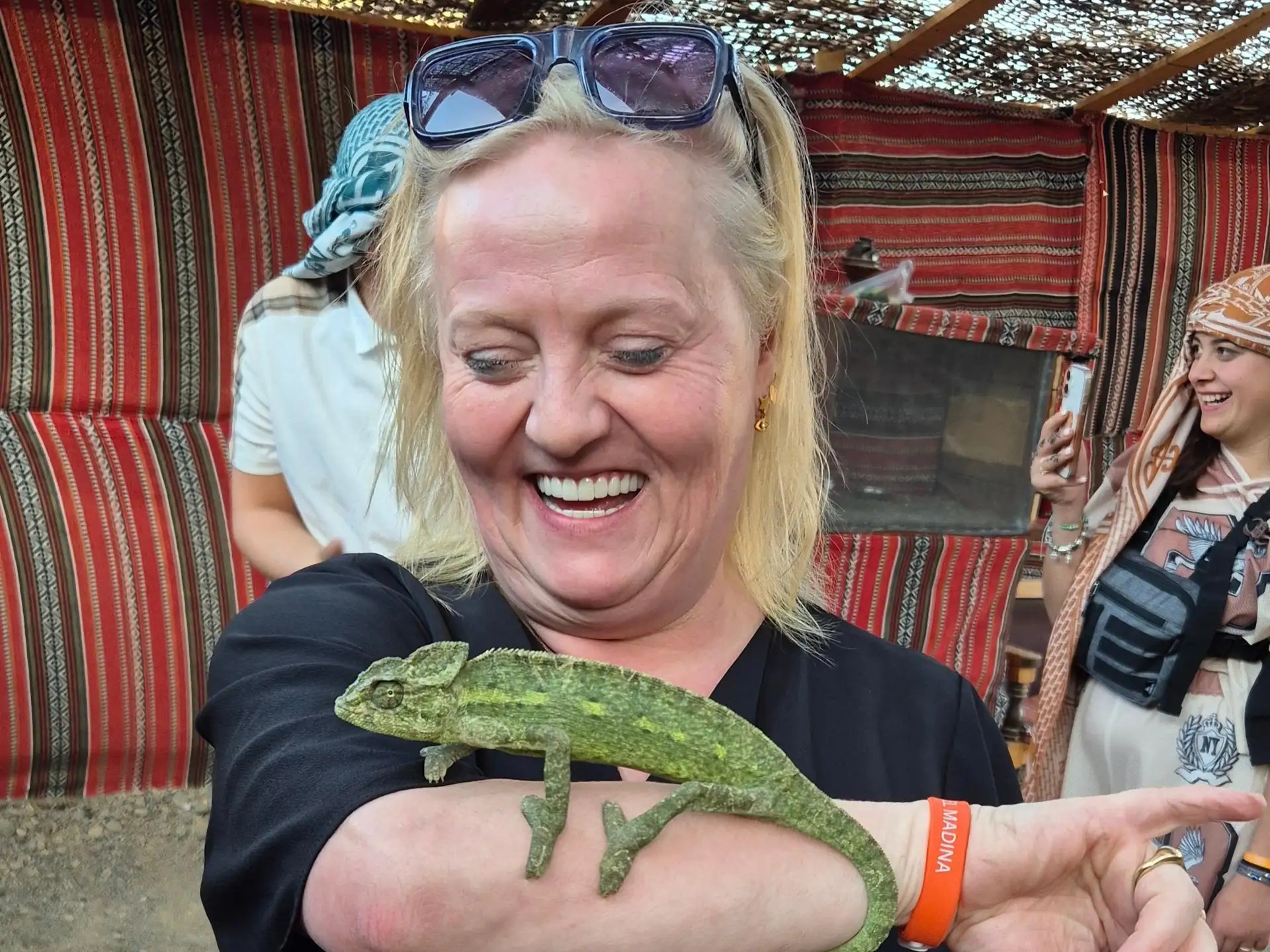 Woman holding a chameleon at Bedouin camp